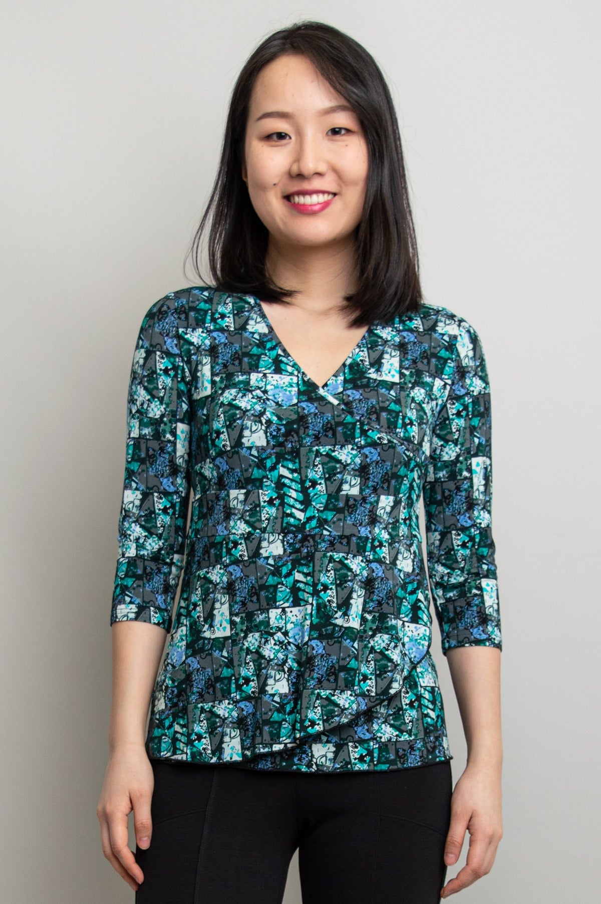 A model wearing a v-neck 3/4 sleeve top in teal colour made with natural Bamboo fabric.