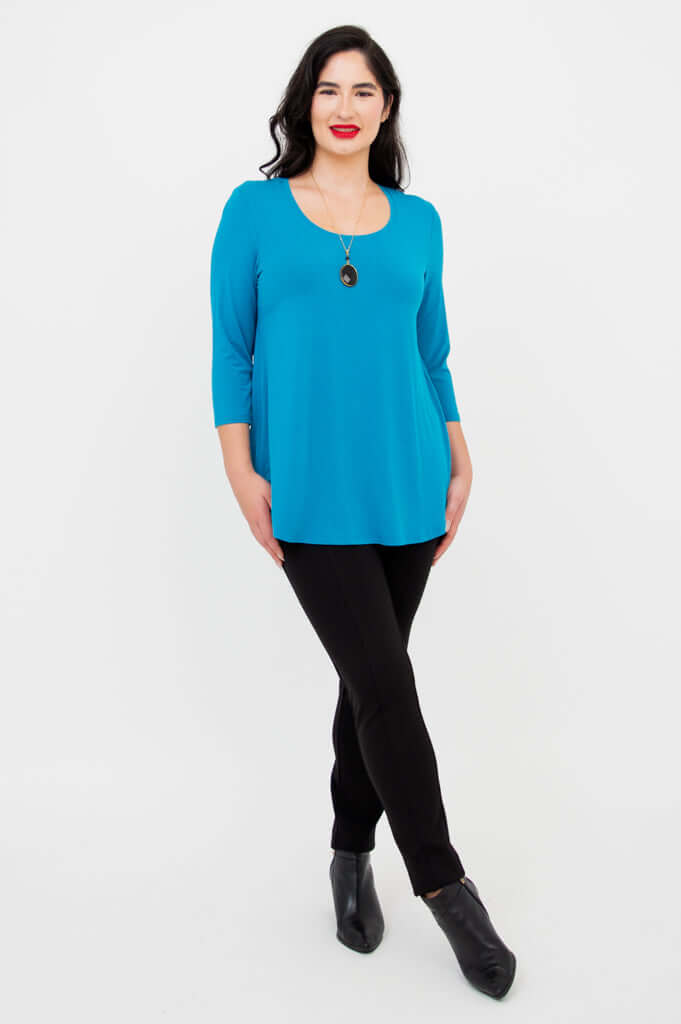 Full body view of a woman in blue 3/4 sleeve top and black pants