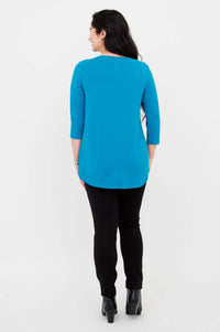 Back view of a woman in blue 3/4 sleeve bamboo top and black pants