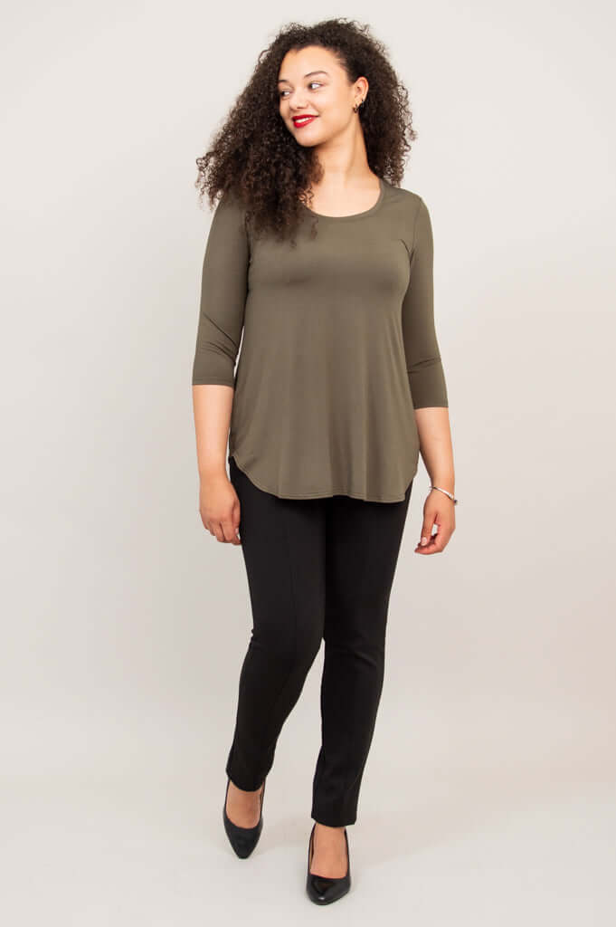 Woman walking in olive 3/4 sleeve bamboo top and black pants