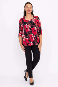 Full front view of a woman modeling a red floral 3/4 sleeve top and black pants