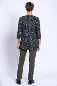 Back view of a woman wearing a black floral 3/4 sleeve bamboo top and green pants