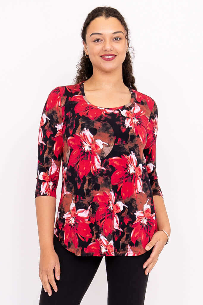 Front view of a woman wearing a black top with bold red floral print and three-quarter sleeves