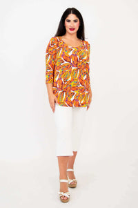 Full front view of model in Jazz 3/4 top, tangerine splash print, with white capri pants