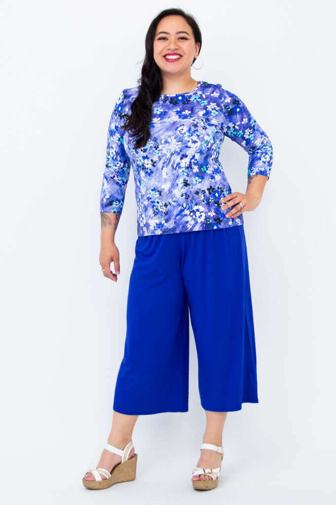 Woman posing in a blue floral print top and matching culotte pants