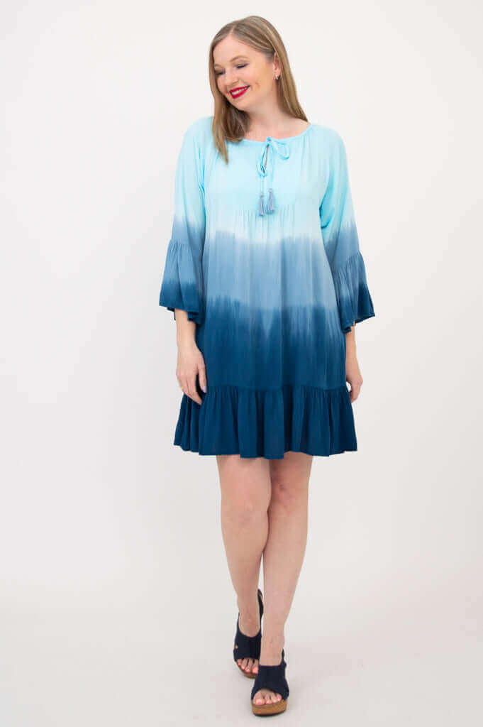 Model posing in blue ombre Ellie Dress, with relaxed fit and 3/4 ruffle sleeves