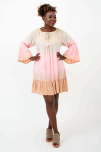 Woman modeling a flowy ombre dress with 3/4 ruffle sleeves and tassel neck tie
