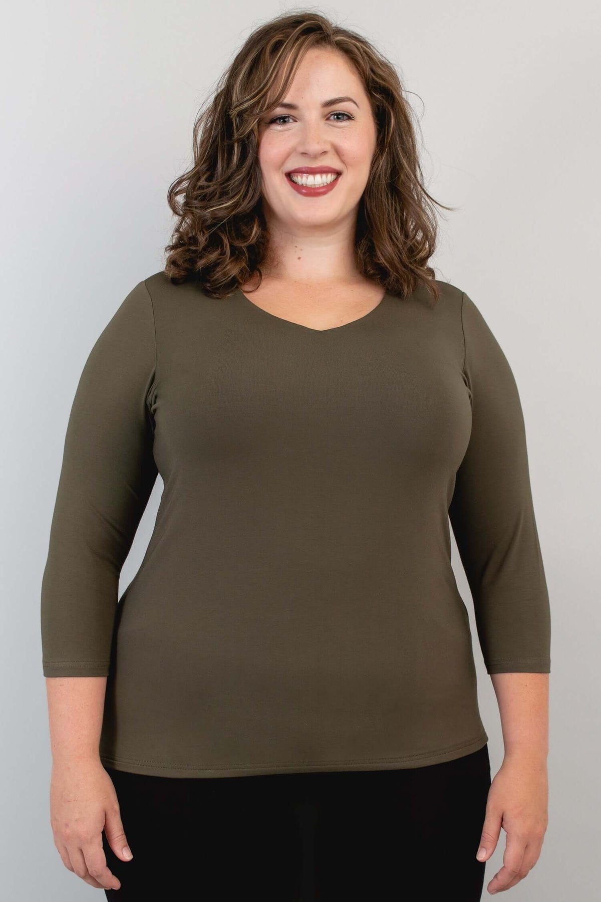 Model wearing olive green 3/4 sleeve V-neck bamboo top, front view