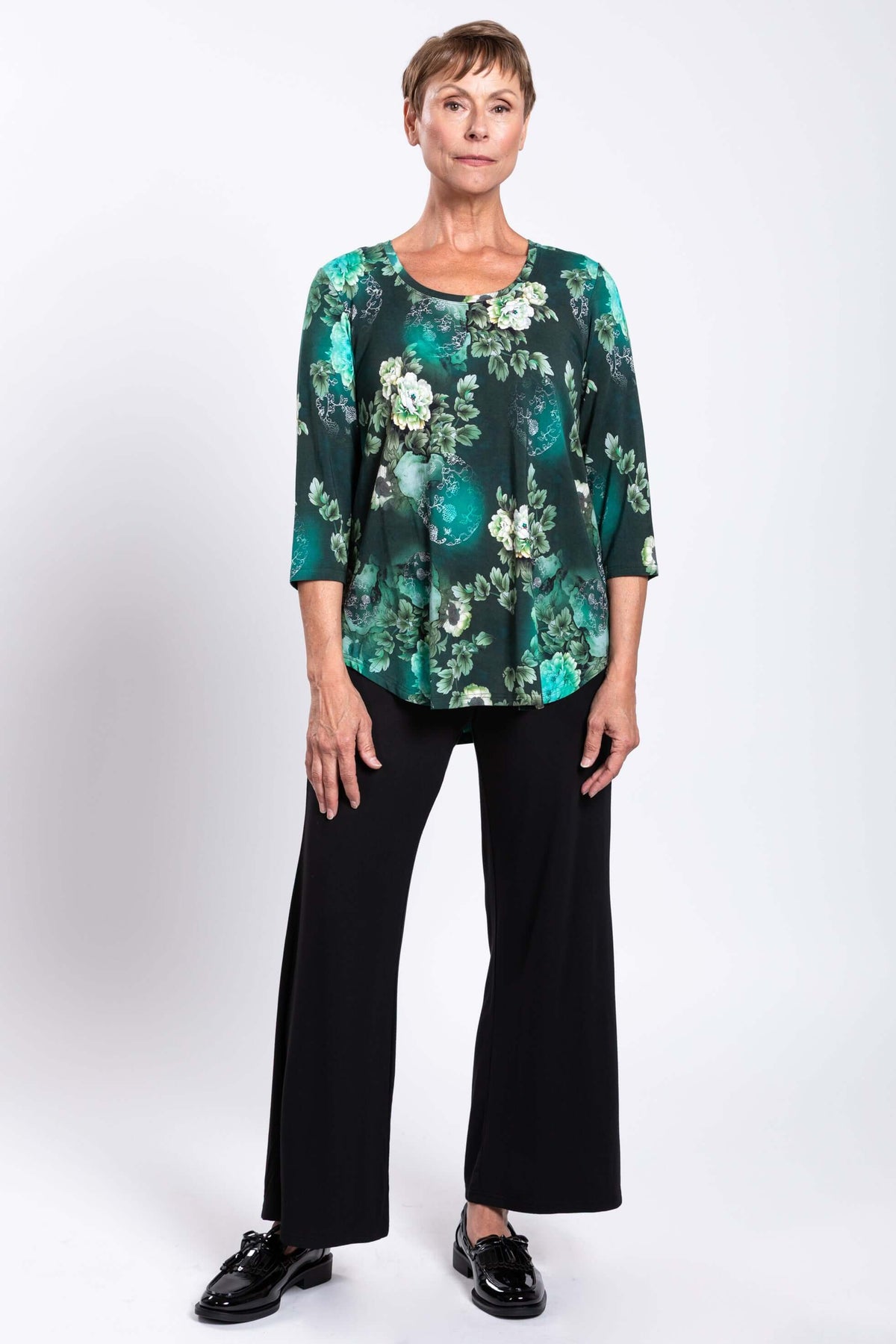 Woman modeling a green floral 3/4 sleeve bamboo top, facing forward