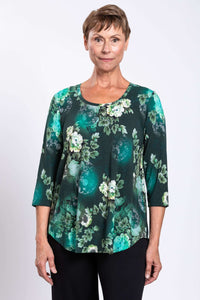 Front view close-up of a woman wearing a green floral 3/4 sleeve bamboo top
