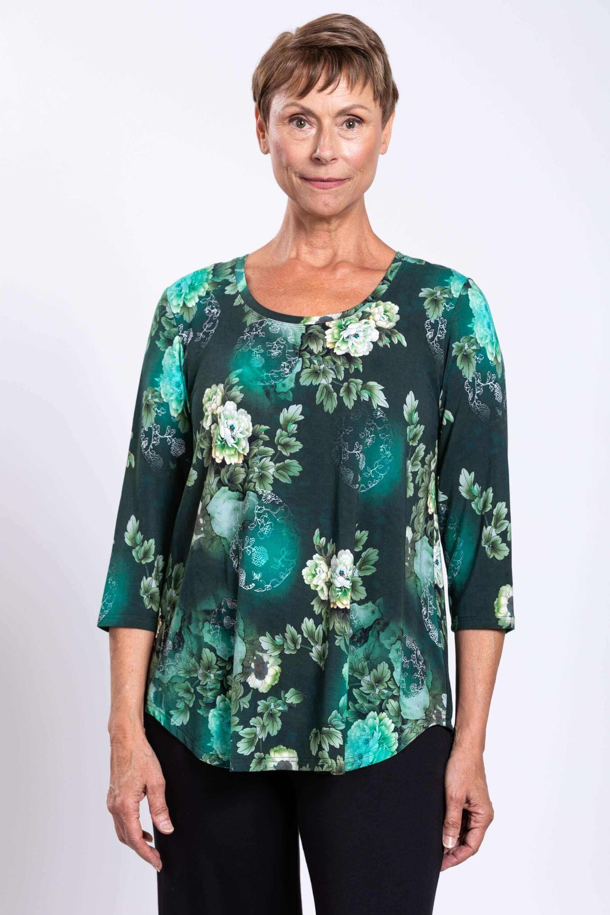 Front view close-up of woman in green floral 3/4 sleeve bamboo top