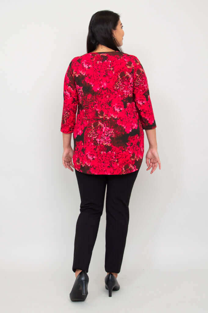 Back view of woman in fuchsia swirl 3/4 sleeve bamboo top and black pants
