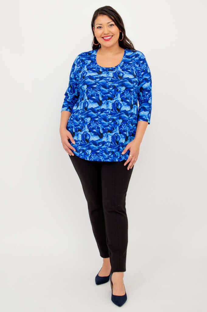Full body view of woman in blue abstract 3/4 sleeve bamboo top and black pants