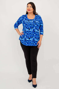 Woman posing in blue abstract bamboo top with 3/4 sleeves and black pants