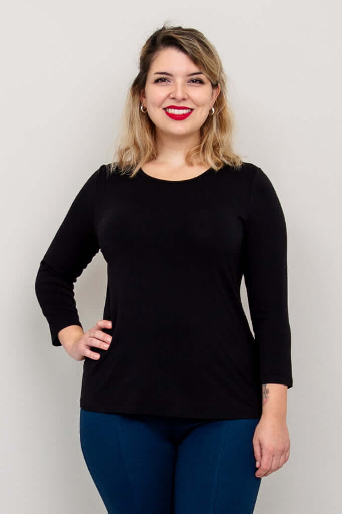 Model wearing a fitted black 3/4 sleeve bamboo tee with blue pants, front view