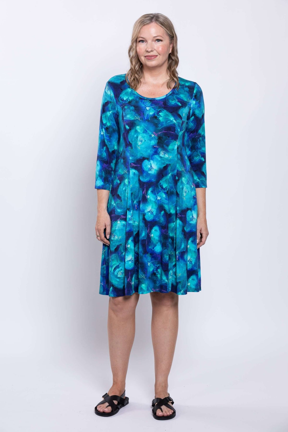Front pose of model in vibrant blue A-line bamboo dress with 3/4 sleeves