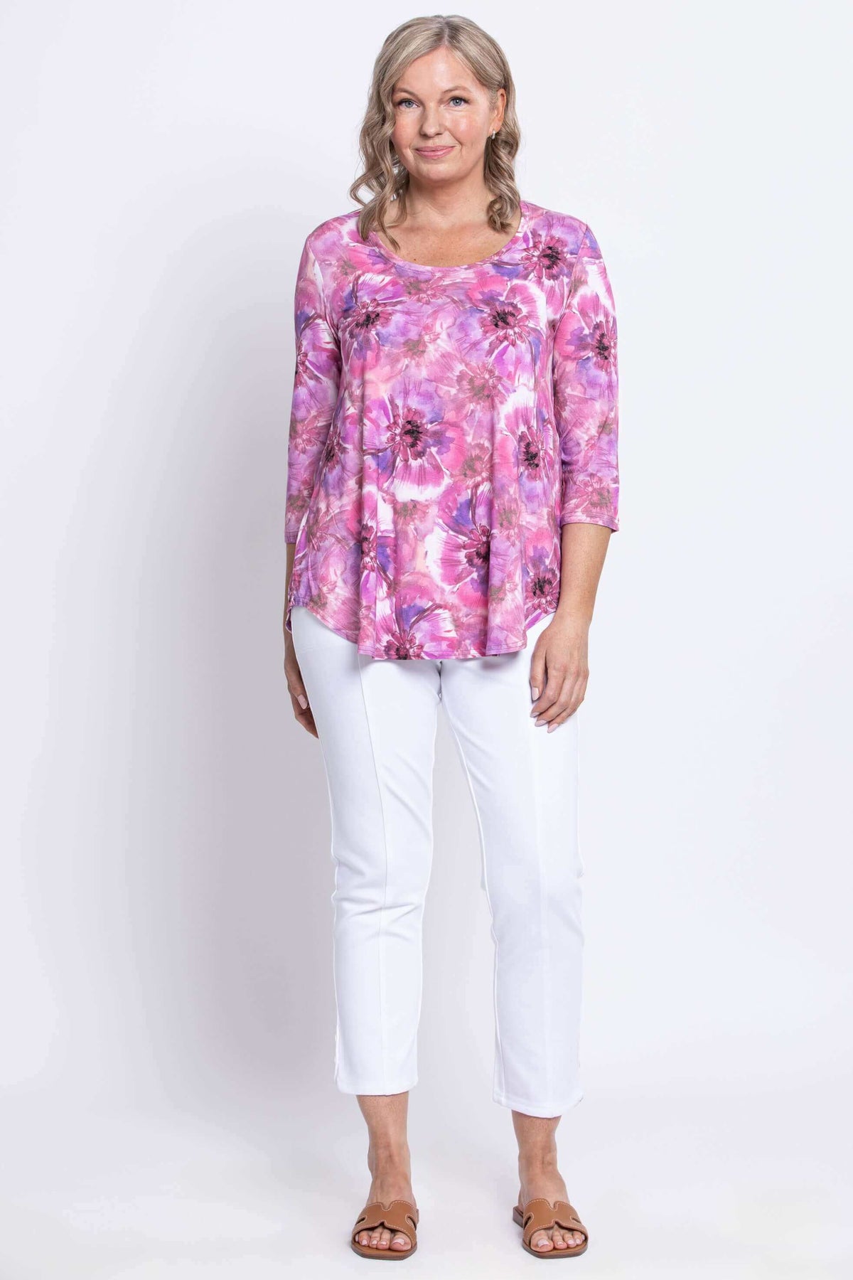 Woman standing in 3/4 sleeve bamboo top with pink floral print and scoop neck, front view