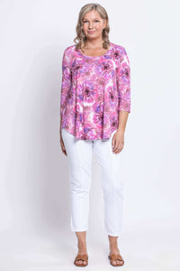 Woman standing in 3/4 sleeve bamboo top with pink floral print and scoop neck, front view