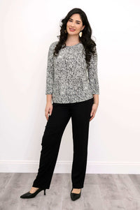 Full body view of woman modeling black and white rose print 3/4 sleeve tee with black pants