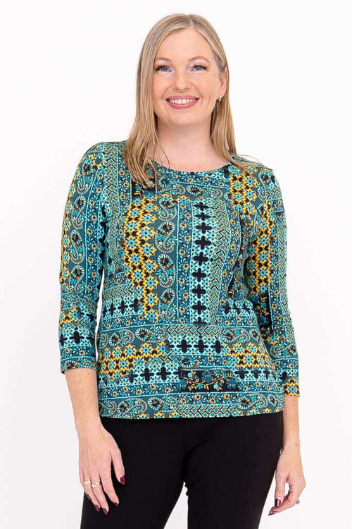 Woman wearing a vibrant blue and yellow patterned 3/4 sleeve tee, front view, smiling