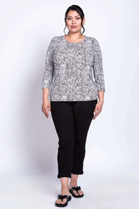 Plus-size woman modeling black and white rose print 3/4 sleeve tee and black pants