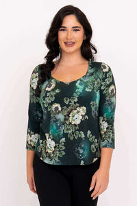 Front view of a woman wearing a green floral 3/4 sleeve sweetheart neckline top