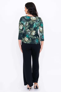 Back view of a woman wearing the green floral 3/4 sleeve top and black pants