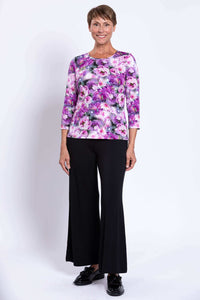 Woman in purple floral 3/4 sleeve top with black wide-leg pants