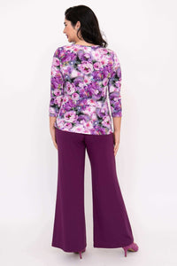 Back view of purple floral 3/4 sleeve top paired with purple pants