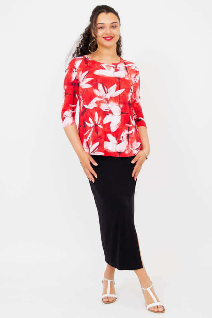 Model standing in a red floral 3/4 sleeve top paired with a long black skirt and white sandals