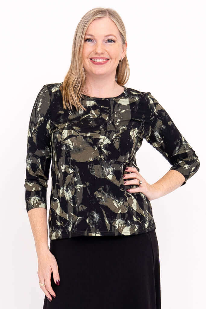 Woman wearing a black brushstroke-pattern 3/4 sleeve top, smiling close-up