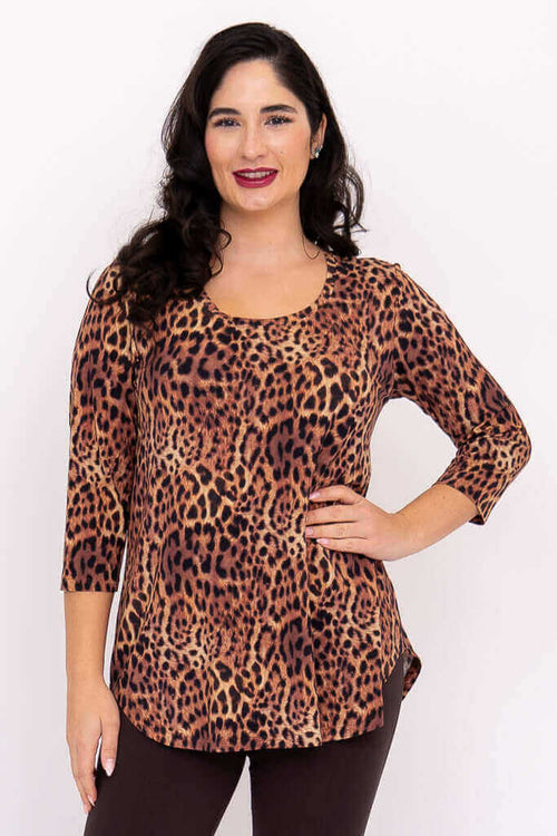 Woman wearing a leopard print 3/4 sleeve top, posing confidently