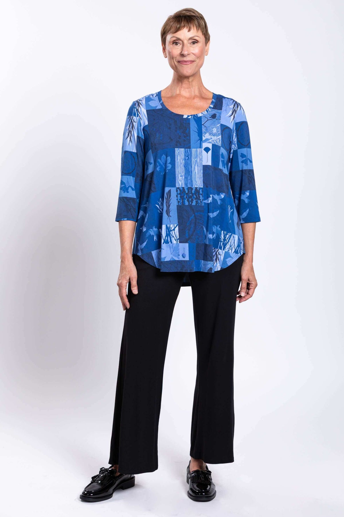Full-body view of model in blue patchwork Jazz 3/4 sleeve top and black pants