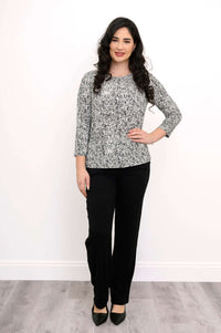 Full body front view of a woman in a rose print fitted 3/4 sleeve tee and black pants