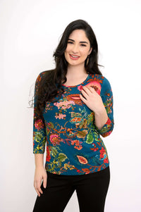 Woman wearing a fitted teal floral bamboo tee with 3/4 sleeves, smiling