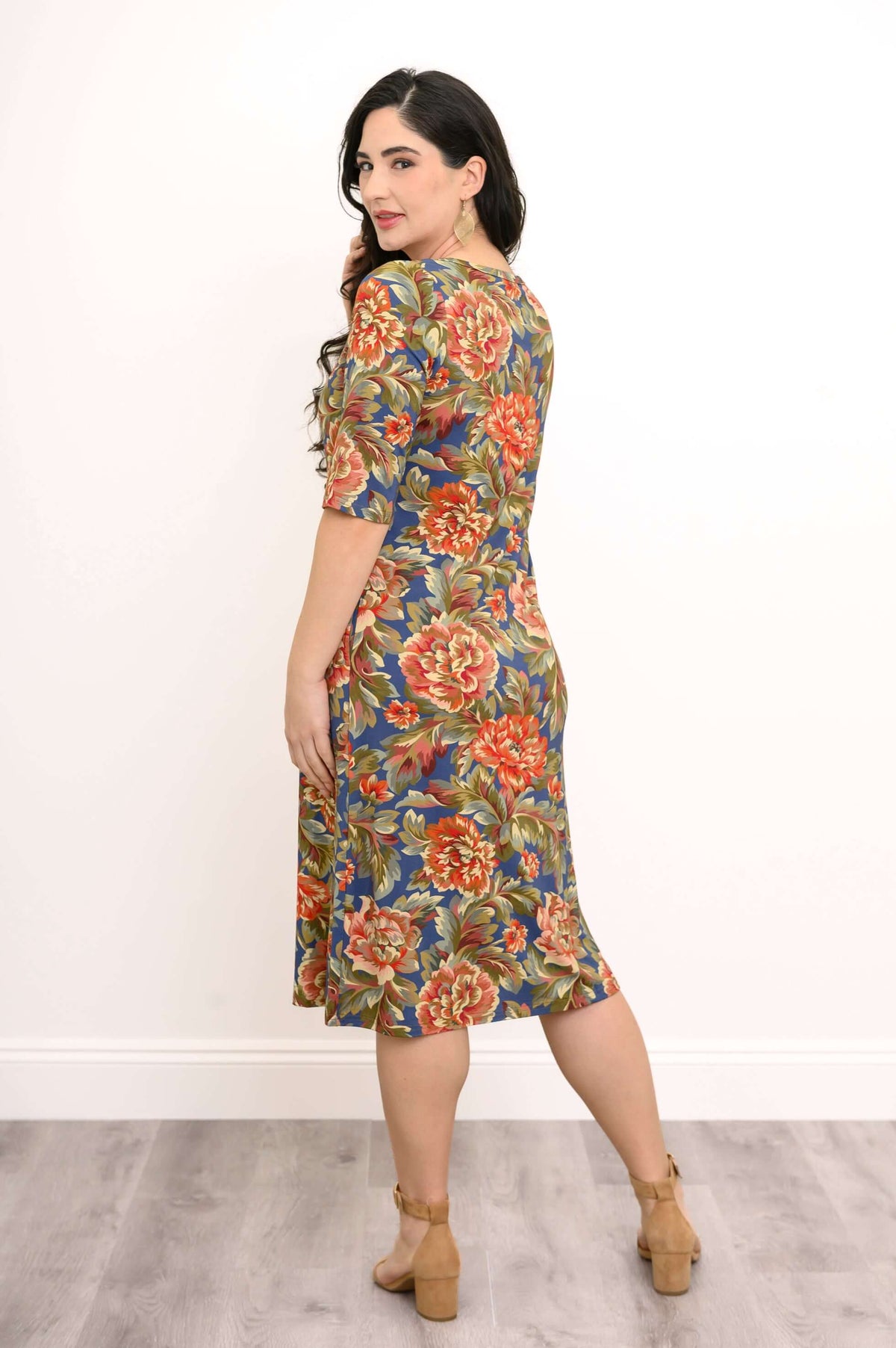 Back view of a woman wearing a floral midi dress with 3/4 sleeves