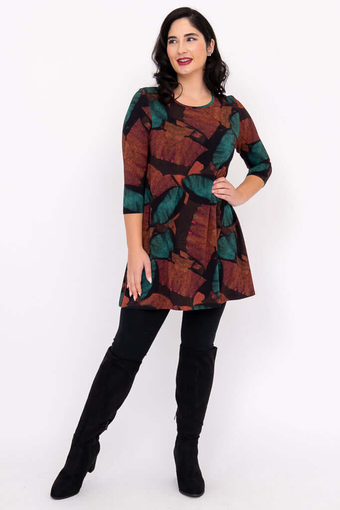 Woman modeling an A-line tunic with bold leaf print, hand on hip