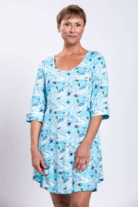 Woman wearing a blue sleepshirt with skier pattern, 3/4 sleeves and scoop neckline