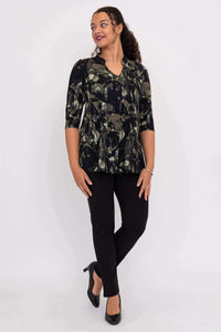 Woman in abstract print bamboo top with hands at sides, looking to the side