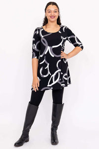 Full-body front view of model in black A-line dress with 3/4 sleeves and monochrome pattern