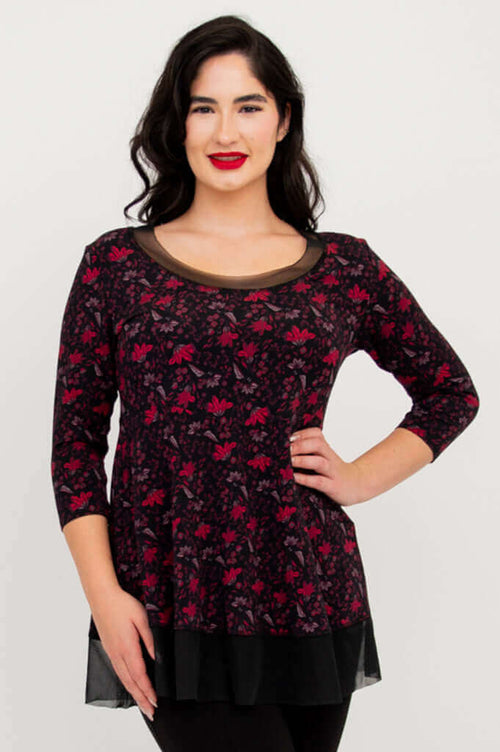 Woman wearing a black and red floral tunic with mesh neckline and hem, 3/4 sleeves