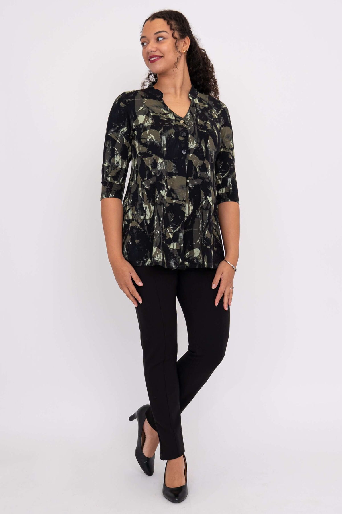 Side-facing woman in a black and green bamboo print top with 3/4 sleeves and Mandarin collar