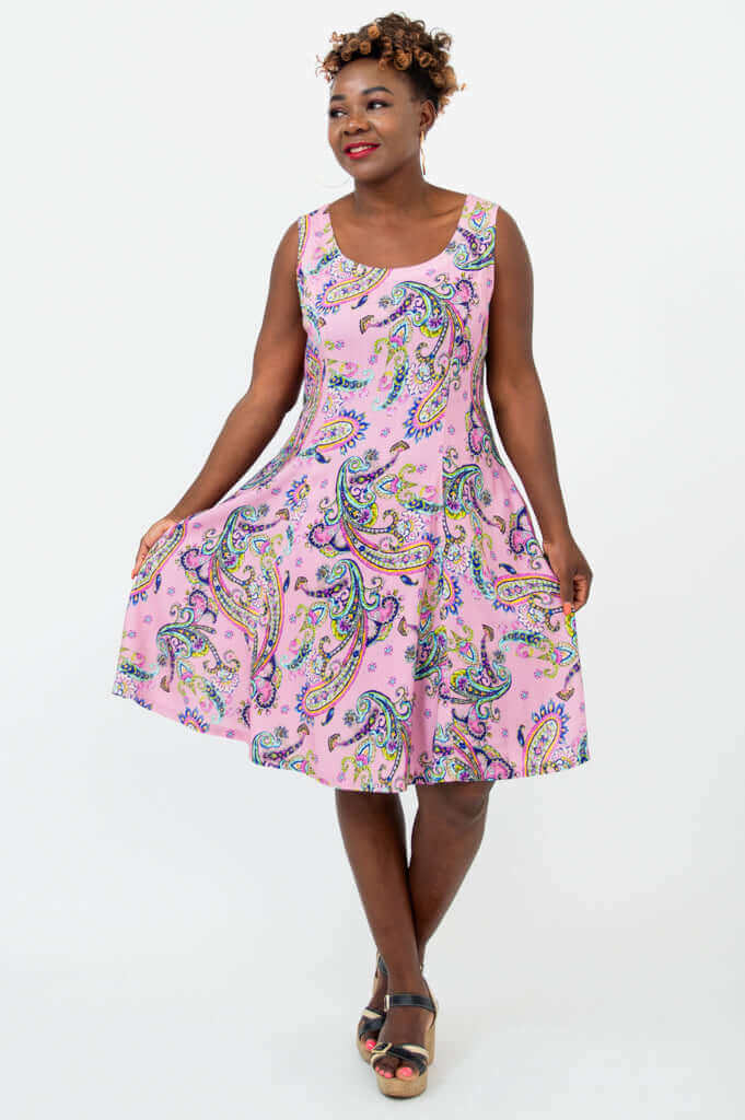 Woman twirling in a pink paisley A-line dress, showing dress flow