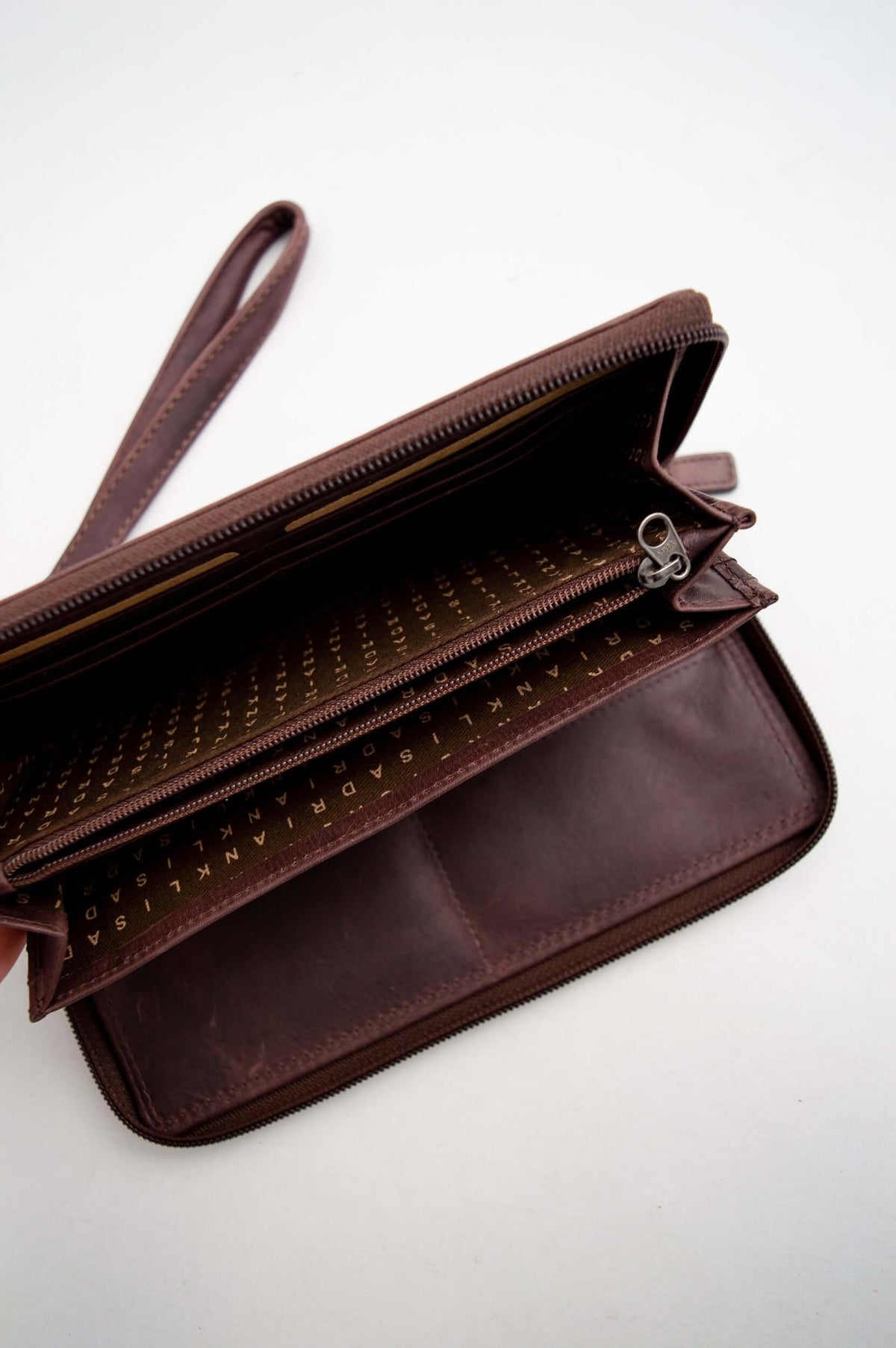 Adrian Klis leather wallet open, displaying interior zippered pouch and logo lining