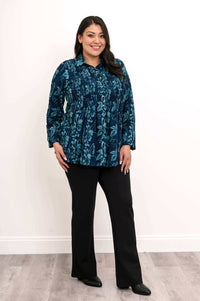 Model angled in blue floral smocked shirt and black pants