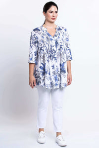 Woman modeling Margate floral blouse and white pants, angled view