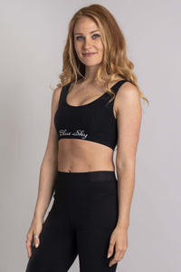 Angled front view of woman in Blue Sky black comfort bra and pants