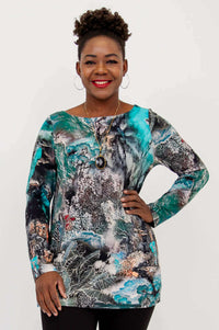 Front angled view of model in cheerful bamboo top with artistic pattern