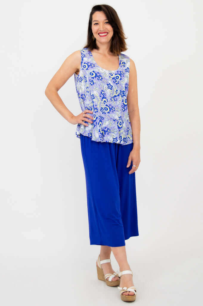 Angled view of model wearing Ginny Peplum Tank in blue paisley print