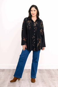 Front angle of a woman in a black smocked tunic with button front and floral print